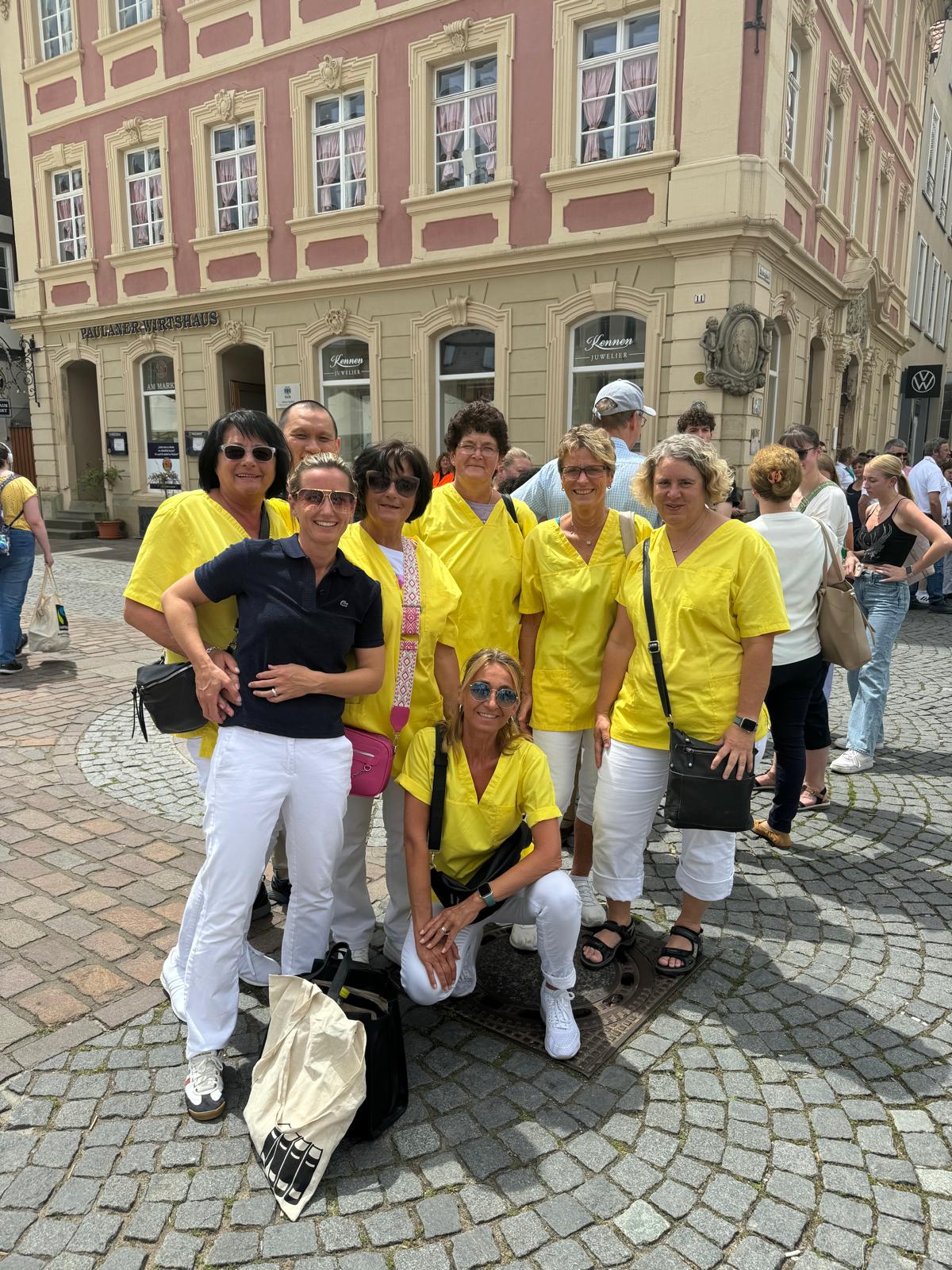 Das Praxisteam der Praxis Sarah Strauch in gelben Kasacks in der Aalener Altstadt